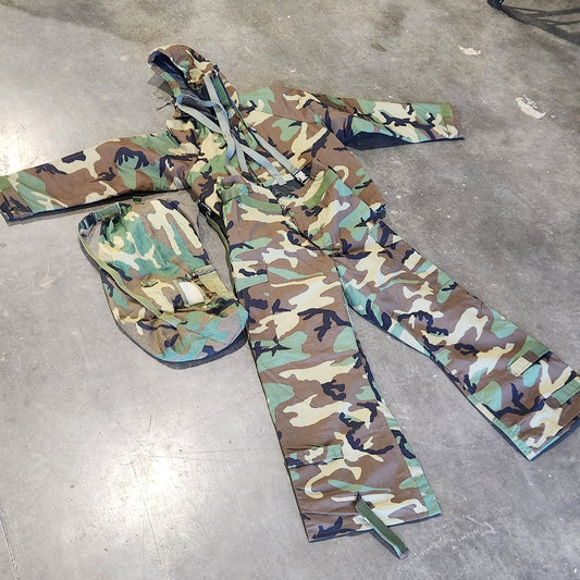 Camouflage-patterned pants on a concrete floor with tools and equipment in the background